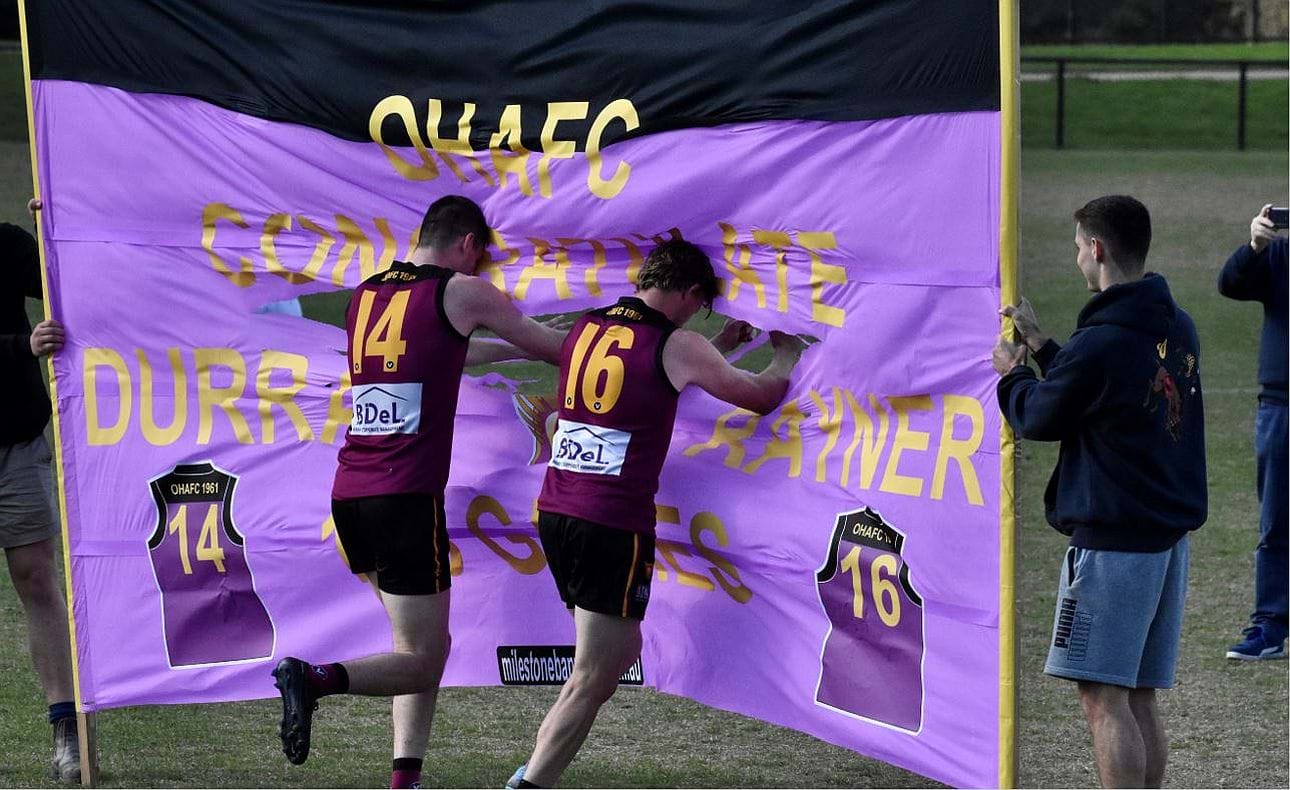 Brothers in arms Durras (14) and Rayner (16) Seccull break the banner to celebrate their hundredth games for the club
