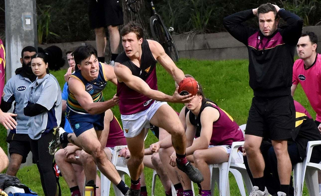 Lachie Riley makes a break for it in the Round 15 match against St Kevins, while coach Guy Martyn  is so close to the action he almost appears to be on the field too