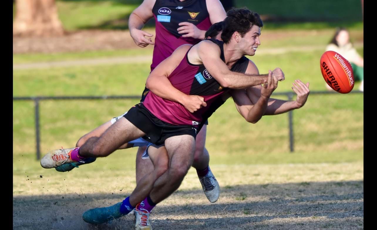 Charlie Sinclair gets his handball despite the tackle