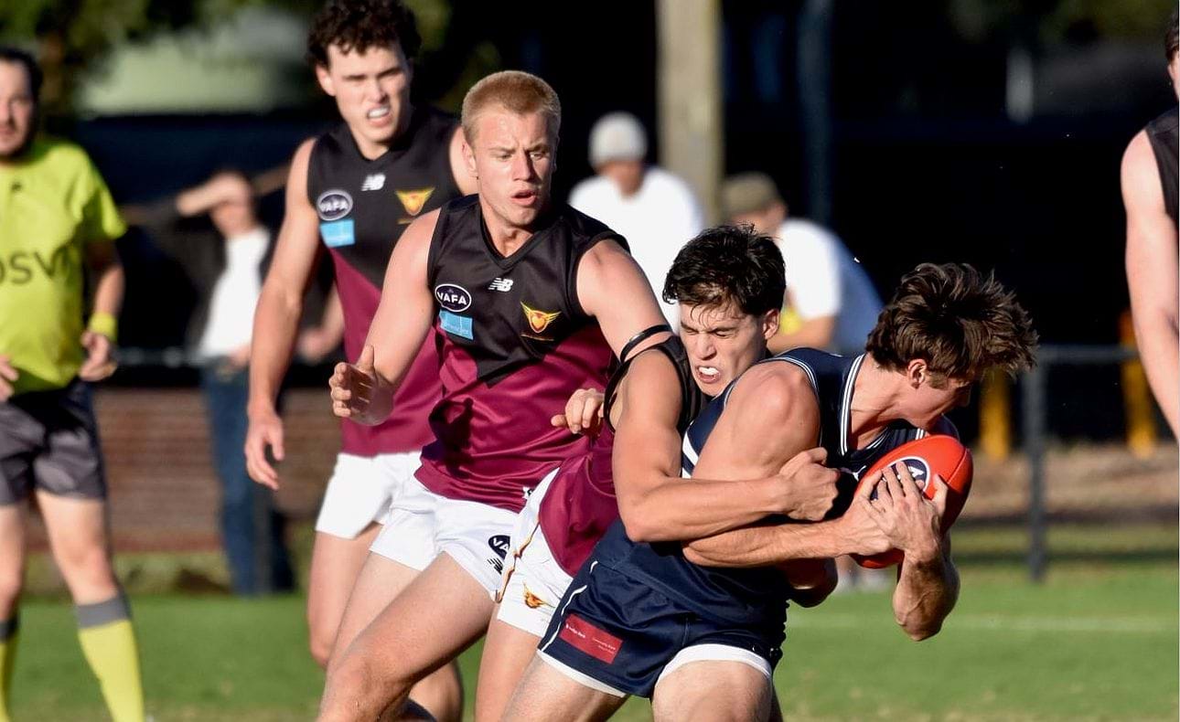 Nick Mavropouos lays a tackle, Lachlan Giliam and Josh Gillon in the background