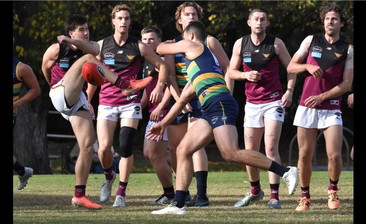 Josh Gasparini's kick slews off the side of his boot as backmen Hugo Lynch, Duras Seccull and Will Paul watch on