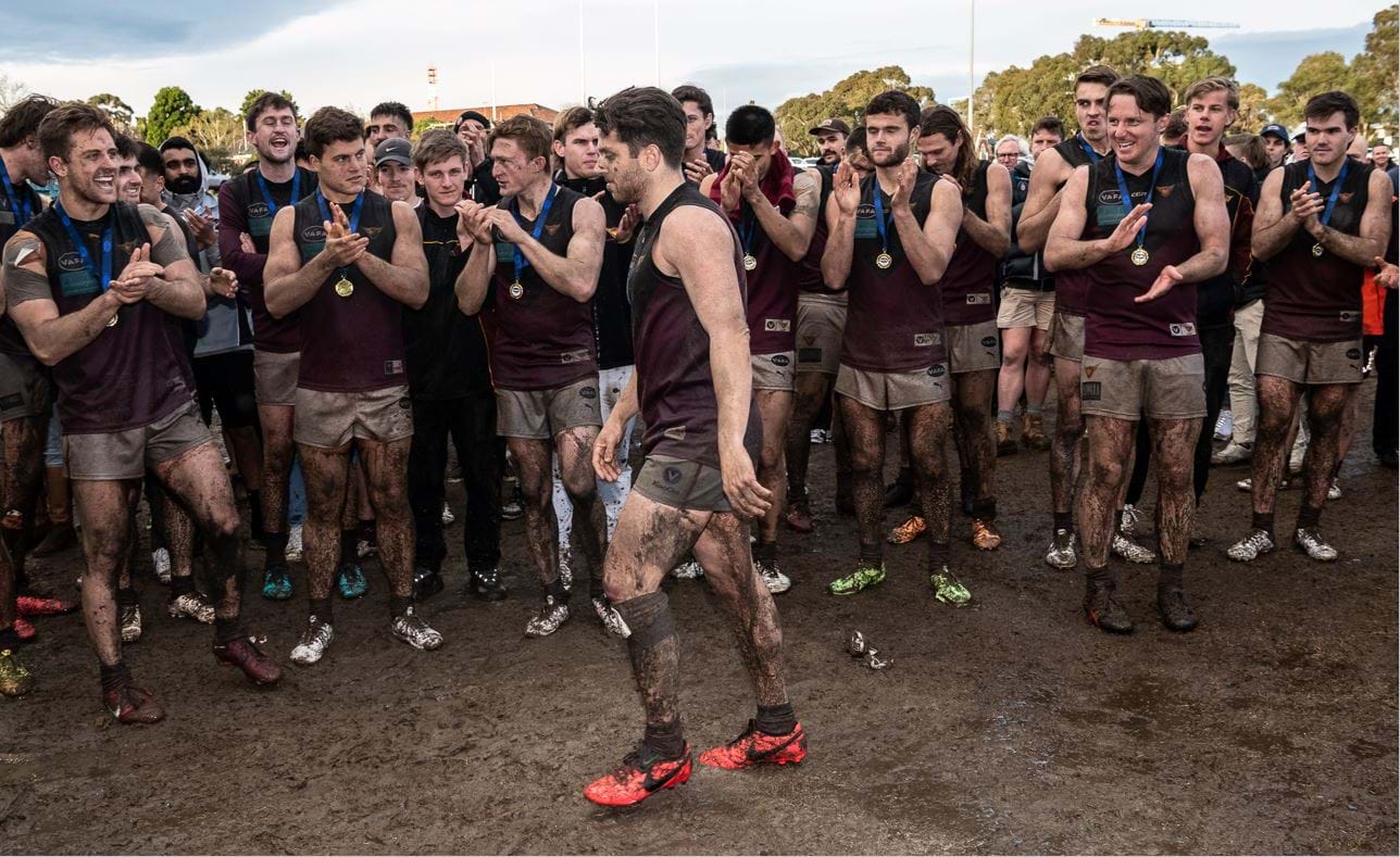 James Paul heads to the podium ahead of his team already with their premiership medals