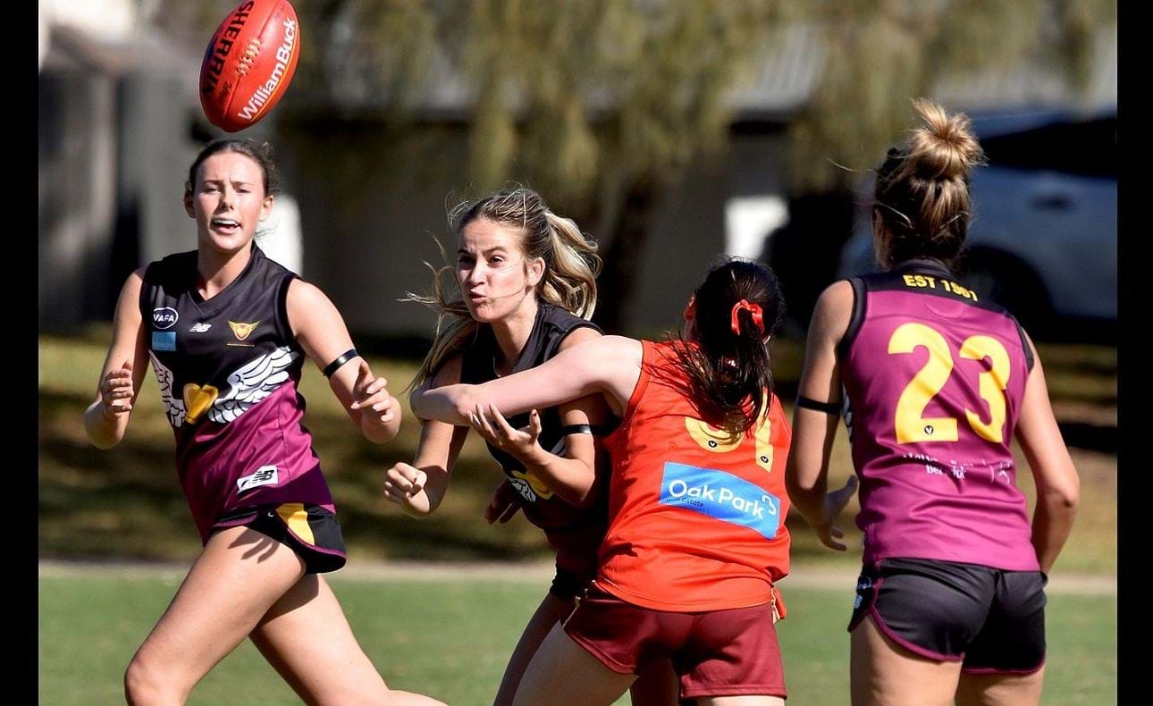 Sienna Turudia handballs, watched by Charlotte Haydn-Evans and Gemma Elcock (23)