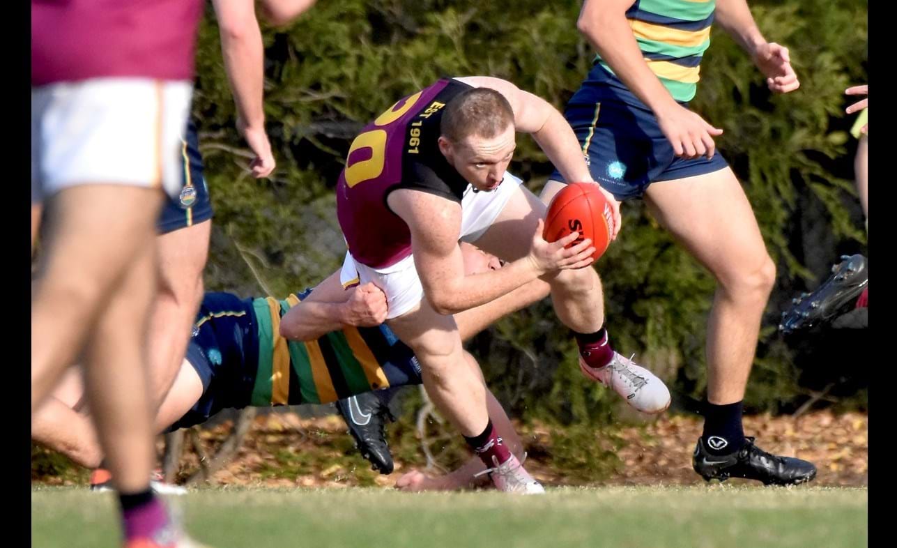 Dre Stefanakis battles to regain his balance from a St Kevin's tackle