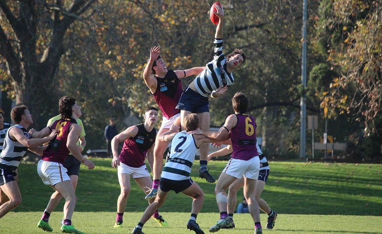 Lachie Vaughan out-stretched in the ruck by his Old Geelong opponent, mid-fielders Luke Bailey, Brede Seccull and Josh Gasparini (6) await the outcome