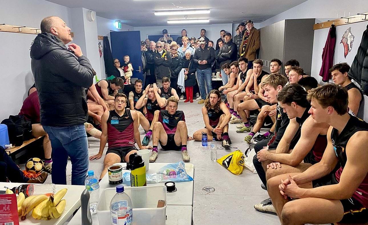 Coach Daniel Ward addresses the players after their narrow but still commendable win