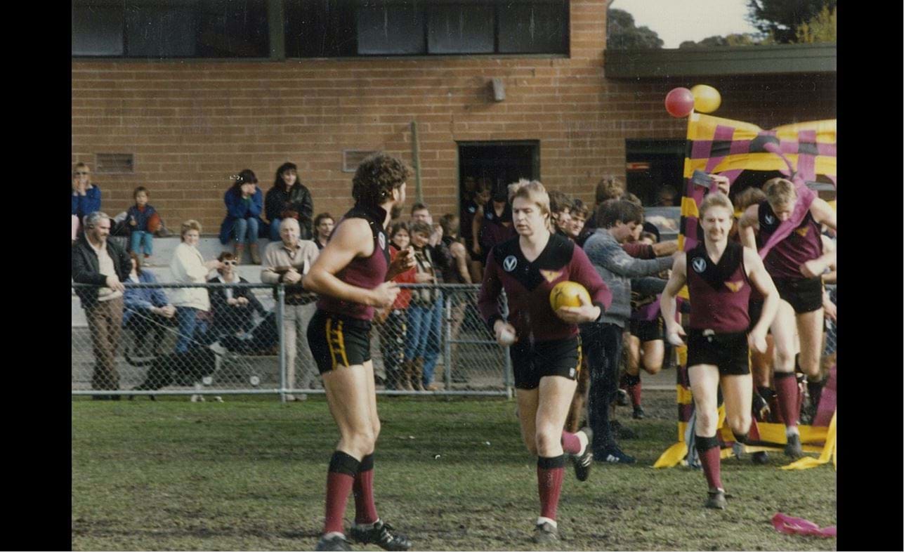 It might look like Captain-coach Wayne Shand is leading the Bloods out at McKinnon in 1986, but Neville Schmidt has already broken the banner for his 200th game held by Tony Doyle. Paul Brewer and Mark Orton follow the veterans out.