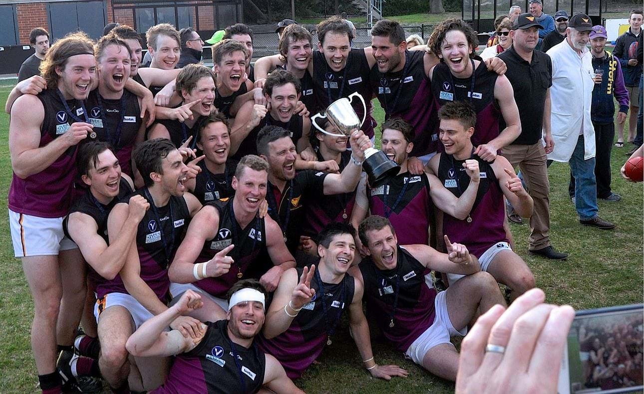 The team celebrates with coach and cup