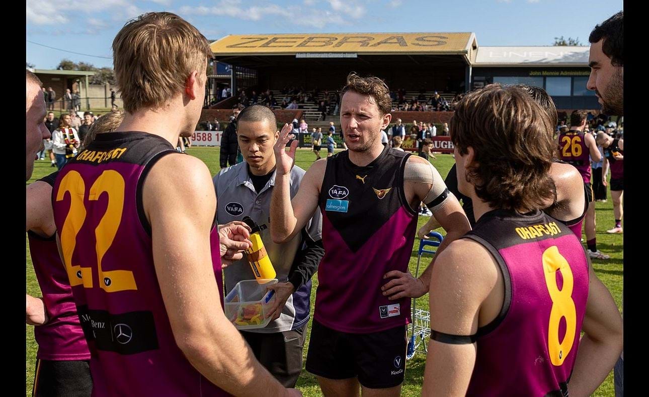 Veteran Peter Gleadhill addresses his fellow mids Mattias Rose (22) and Noah Higgins (8) at quarter time
