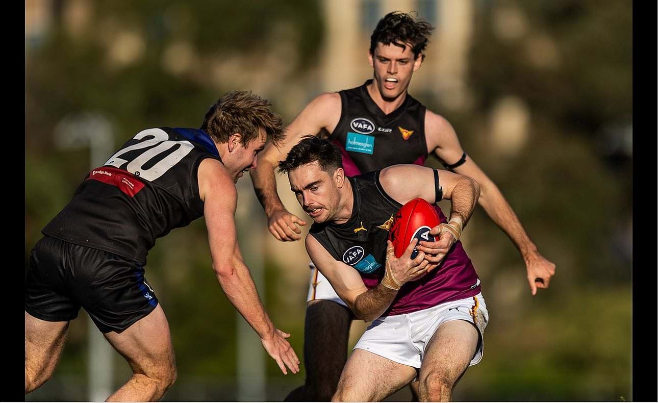 Jayce Morgan clutches the ball to his chest, Ky Turner backs up behind